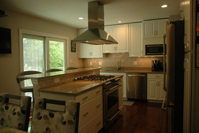 Eat-in kitchen - mid-sized traditional l-shaped medium tone wood floor and brown floor eat-in kitchen idea in Other with an undermount sink, raised-panel cabinets, white cabinets, granite countertops, beige backsplash, stainless steel appliances and an island