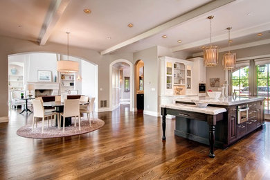 Open concept kitchen - large traditional medium tone wood floor open concept kitchen idea in Denver with raised-panel cabinets, dark wood cabinets, marble countertops and an island