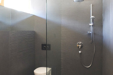 Mittelgroßes Modernes Duschbad mit bodengleicher Dusche, grauen Fliesen, grauer Wandfarbe und Betonboden