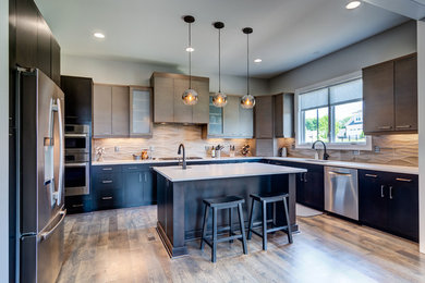 Large minimalist u-shaped medium tone wood floor and brown floor eat-in kitchen photo in Other with a drop-in sink, flat-panel cabinets, dark wood cabinets, stainless steel appliances and an island