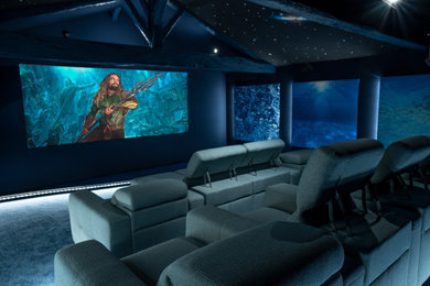 Exemple d'une grande salle de cinéma fermée avec un mur bleu, moquette, un écran de projection et un sol bleu.