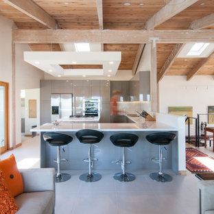 Midcentury modern open concept kitchen inspiration - Example of a 1960s u-shaped white floor open concept kitchen design in San Diego with an undermount sink, flat-panel cabinets, gray cabinets, white backsplash, glass sheet backsplash, stainless steel appliances and a peninsula