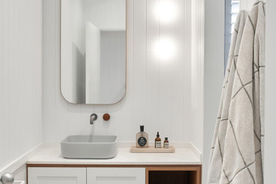 Design ideas for a mid-sized contemporary bathroom in Sydney with shaker cabinets, white cabinets, an alcove shower, a one-piece toilet, blue tile, ceramic tile, white walls, porcelain floors, a vessel sink, engineered quartz benchtops, beige floor, a hinged shower door, white benchtops, a single vanity, a built-in vanity and panelled walls.
