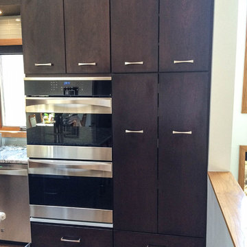 Cherry cabinets with slab doors, a custom-mixed stain, Bianco Antico granite and