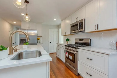 Kitchen - small modern l-shaped medium tone wood floor and brown floor kitchen idea in Boston with an undermount sink, shaker cabinets, white cabinets, quartzite countertops, white backsplash, subway tile backsplash, stainless steel appliances, an island and multicolored countertops