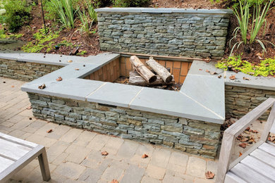 This is an example of a small traditional backyard patio in Atlanta with a fire feature, natural stone pavers and no cover.