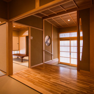 他の地域の引き戸アジアンスタイルのおしゃれな玄関 (茶色い壁、御影石の床、グレーの床) の写真