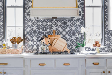 Elegant dark wood floor and brown floor kitchen photo in Dallas with raised-panel cabinets, gray cabinets, black backsplash and white countertops