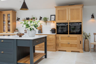 This is an example of a large open plan kitchen in Other with medium wood cabinets, porcelain flooring, an island and beige floors.