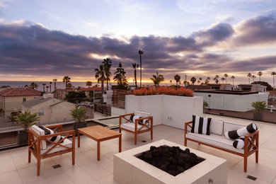 Inspiration for a mid-sized contemporary balcony remodel in San Diego with a fireplace and no cover