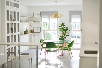 This is an example of a mid-sized contemporary kitchen/dining combo in Madrid with white walls and no fireplace.