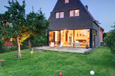 Mittelgroßes, Dreistöckiges Modernes Haus mit Steinfassade, Satteldach und schwarzer Fassadenfarbe in Hamburg