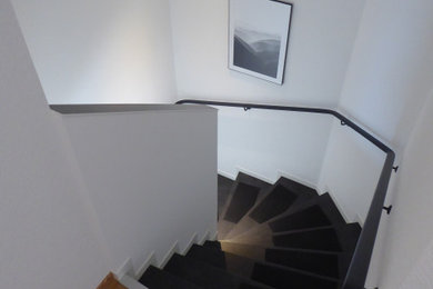 Mittelgroße Moderne Treppe in U-Form mit Schiefer-Treppenstufen, Glas-Setzstufen und Stahlgeländer in Frankfurt am Main