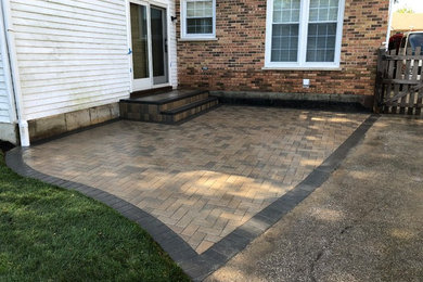 Design ideas for a mid-sized modern backyard patio in Chicago with brick pavers and no cover.