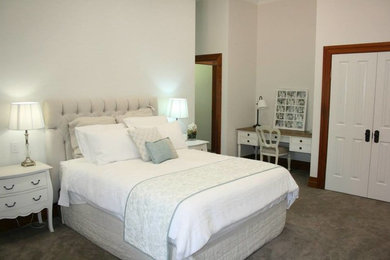 Large contemporary master bedroom in Sydney with beige walls and carpet.