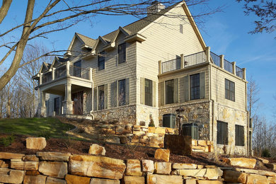 Example of a large classic beige two-story wood exterior home design in Other