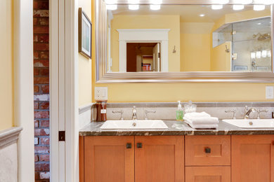 Inspiration for a mid-sized craftsman master beige tile and porcelain tile slate floor bathroom remodel in Calgary with a drop-in sink, shaker cabinets, medium tone wood cabinets, granite countertops, a two-piece toilet and yellow walls