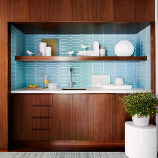 ニューヨークのビーチスタイルのおしゃれなウェットバー (アンダーカウンターシンク、フラットパネル扉のキャビネット、濃色木目調キャビネット、青いキッチンパネル、濃色無垢フローリング、茶色い床、白いキッチンカウンター) の写真