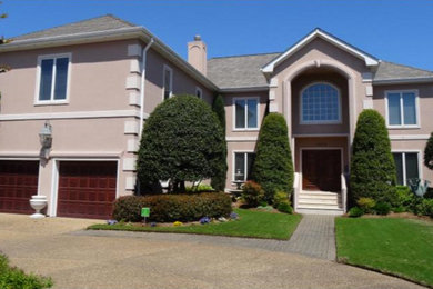 Large elegant beige two-story stucco house exterior photo in Other with a hip roof and a shingle roof