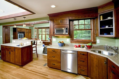 Inspiration for a large timeless l-shaped medium tone wood floor and brown floor enclosed kitchen remodel in Orange County with an undermount sink, shaker cabinets, dark wood cabinets, granite countertops, stainless steel appliances and an island