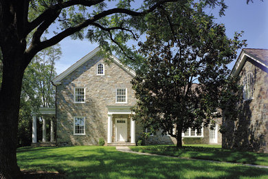 This is an example of a traditional two-storey exterior in DC Metro with stone veneer and a gable roof.