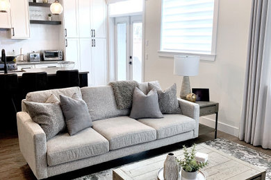Mid-sized minimalist open concept medium tone wood floor, exposed beam and brown floor living room photo in Vancouver with white walls, a standard fireplace, a tile fireplace and a wall-mounted tv
