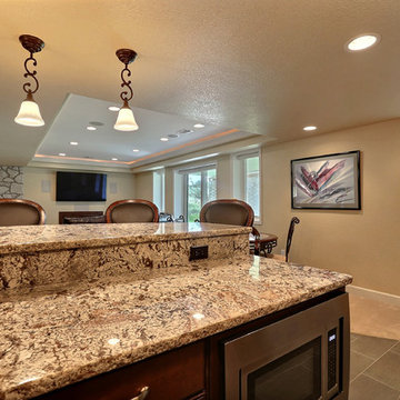 Open Basement Concept in Centennial, CO with tray ceilings and stacked stone
