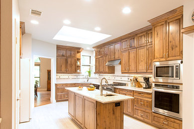 Mountain style eat-in kitchen photo in Austin with an undermount sink, stainless steel appliances and an island