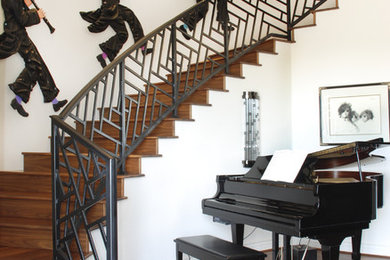 Example of a trendy wooden curved staircase design in Phoenix with wooden risers