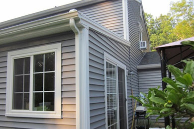Inspiration for a large gray two-story vinyl exterior home remodel in New York