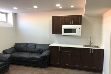 Basement - mid-sized modern underground vinyl floor and gray floor basement idea in Other with beige walls