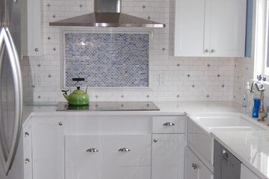 Example of a mid-sized transitional u-shaped medium tone wood floor and brown floor kitchen design in Sacramento with a farmhouse sink, flat-panel cabinets, white cabinets, quartz countertops, white backsplash, subway tile backsplash, stainless steel appliances and no island