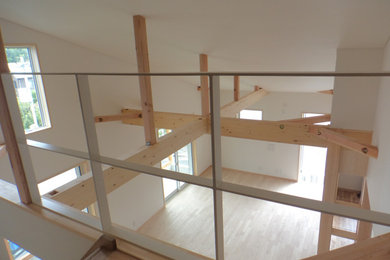 Imagen de sala de estar abierta y blanca pequeña con paredes blancas, suelo de madera clara, papel pintado y madera