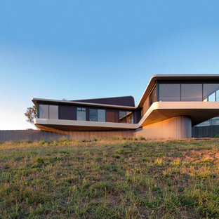 シドニーのコンテンポラリースタイルのおしゃれな二階建ての家 (ガラスサイディング、ベージュの外壁) の写真