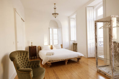 Inspiration for a large traditional bedroom in Other with beige walls and light hardwood floors.