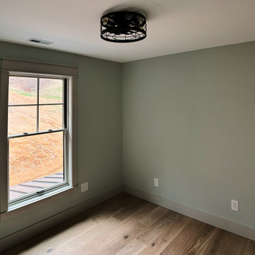 Cozy Modern Farmhouse Office: Light Oak Floors, Soft Green Walls, and Warm Light