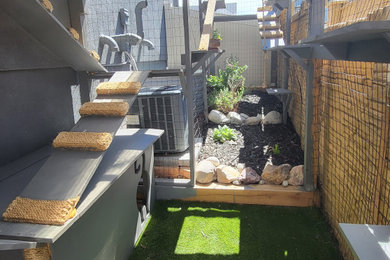 Photo of a large tropical full sun hillside mulch and metal fence formal garden in Denver.