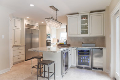 Large traditional l-shaped eat-in kitchen in Houston with an undermount sink, shaker cabinets, white cabinets, granite benchtops, beige splashback, subway tile splashback, stainless steel appliances, limestone floors, a peninsula, beige floor and beige benchtop.