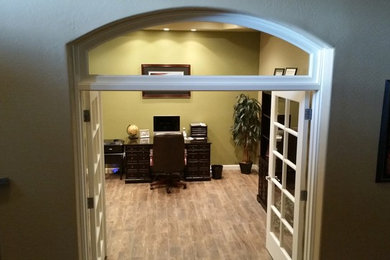 Photo of a mid-sized traditional study room in Phoenix with green walls, medium hardwood floors, no fireplace and a freestanding desk.