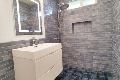 Inspiration for a medium sized contemporary ensuite bathroom in San Francisco with white cabinets, a built-in shower, blue tiles, ceramic tiles, ceramic flooring, a wall-mounted sink, solid surface worktops, blue floors, white worktops, a wall niche and a single sink.