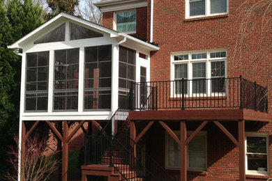 This is an example of a mid-sized traditional screened-in back porch design in Charlotte with decking and a roof extension.