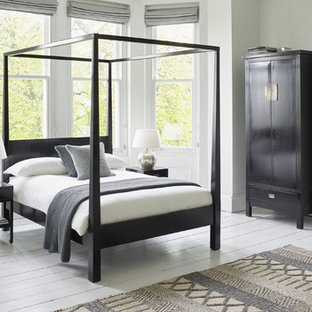 Idee per una grande camera matrimoniale etnica con pareti grigie, pavimento in legno verniciato, camino classico e cornice del camino in intonaco