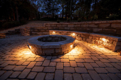 Inspiration for a mid-sized craftsman backyard stone patio remodel in Charlotte with a fire pit and no cover