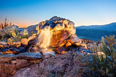 Design ideas for a large traditional backyard stone water fountain landscape in Denver.