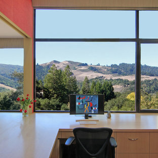 サンフランシスコの中サイズのモダンスタイルのおしゃれな書斎 (赤い壁、無垢フローリング、暖炉なし、造り付け机) の写真