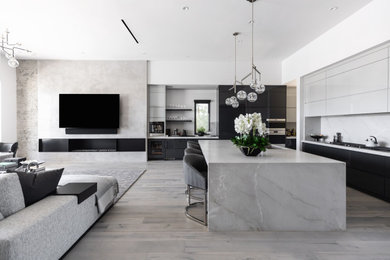 Inspiration for a contemporary l-shaped gray floor kitchen remodel in Phoenix with an undermount sink, flat-panel cabinets, black cabinets, white backsplash, stone slab backsplash, stainless steel appliances, an island and white countertops