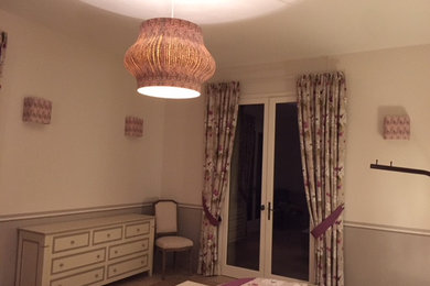 Modelo de habitación de invitados clásica de tamaño medio con paredes beige, suelo de madera clara y suelo beige
