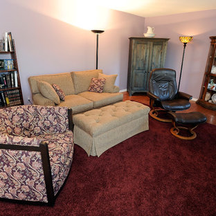 Modelo de salón cerrado, mediterráneo, grande, con paredes púrpuras, suelo de madera en tonos medios, chimenea tradicional y marco de chimenea de ladrillo