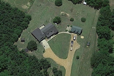 Example of a mid-sized classic red one-story brick house exterior design in Other with a gambrel roof and a metal roof
