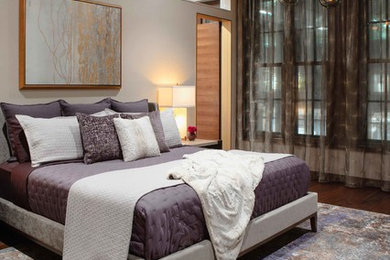 Example of a large trendy master dark wood floor and brown floor bedroom design in Boise with beige walls and no fireplace